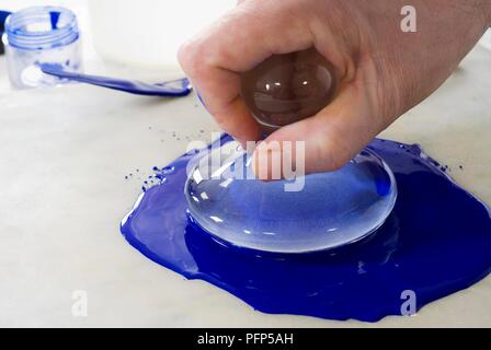 Using glass muller to grind ultramarine pigment and oil on slab Stock Photo  - Alamy