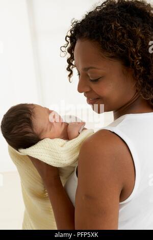 Woman holding baby boy wrapped in baby blanket Stock Photo