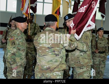 Brig. Gen. Dennis LeMaster, outgoing Regional Health Command Europe Commanding General, passes the colors to Maj. Gen. Jeffrey Clark (center), U.S. Army Medical Command Deputy Commanding General (Operations) during a Change of Command Ceremony, May 23, 2018 at Sembach Kaserne, Germany Stock Photo