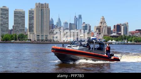 Coast Guard assets from Coast Guard Sector Delaware Bay and the Coast Guard Auxiliary in Philadelphia enforce a safety zone for the parade of sail for Sail Philadelphia 2018 as tall ships from around the world transit the Delaware River in Philadelphia, May 24, 2018. Ships will be docked along the Delaware River Waterfront from Market Street to the end of the Penn’s Landing Marina. Stock Photo