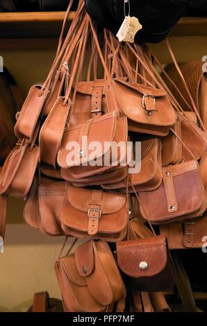Greece, handmade leather handbags hanging on market stall Stock Photo