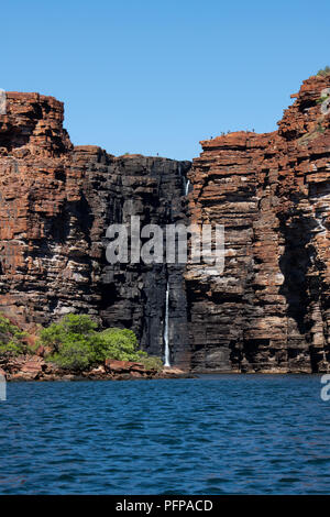 Australia, Western Australia, King George River, King George Falls. Hikers on top of the cliff overlooking the falls. Stock Photo