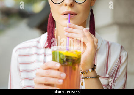 Close up of a woman drinking lemonade with a straw Stock Photo