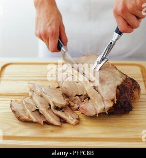 Chef Slicing Roast Beef Using Carving Knife And Fork Stock Photo