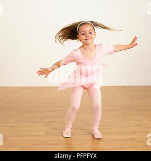 Girl in ballet costume with arms outstretched, 5 years old Stock Photo