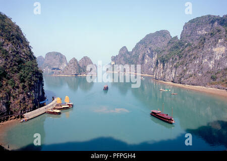 Vietnam, Halong Bay, boats in bay lined by limestone karst rock formations Stock Photo