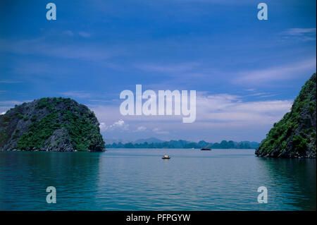 Vietnam, Halong Bay, boats on sea between two limestone karst formations Stock Photo