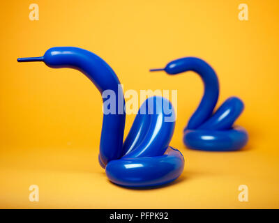 Blue balloon swans on yellow background Stock Photo