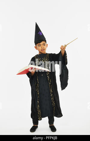 Wizard with a book and a wand Stock Photo