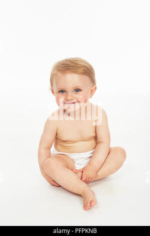 Baby in nappy sitting  (Model age - 9 months) Stock Photo