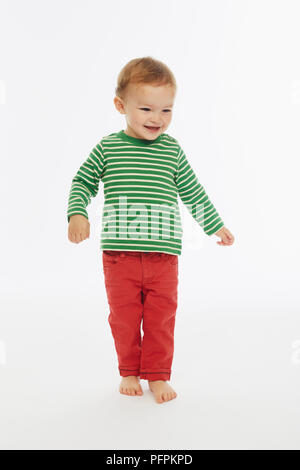 Little boy in green stripey top playing (Model age - 22 months) Stock Photo