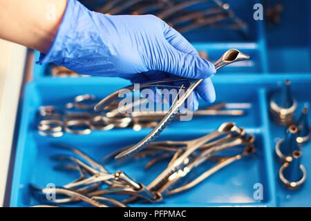 Doctor's hand in disposable nitrile medical gloves holding a nasal speculum for ENT examination Stock Photo