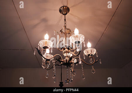 Ornate Vintage lamp illuminated gold chandelier. Stock Photo