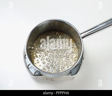 Sugar and water boiling in saucepan, close-up Stock Photo