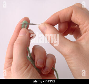 hand threading a needle with black thread Stock Photo - Alamy