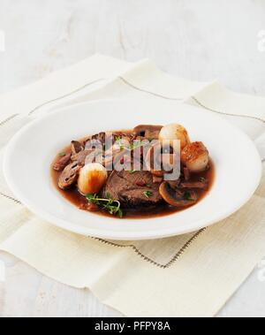 Boeuf a la Bourguignonne (Boeuf Bourguignon), beef with roast onions and mushrooms in sauce Stock Photo