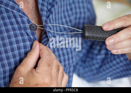 Older man using button hook Stock Photo