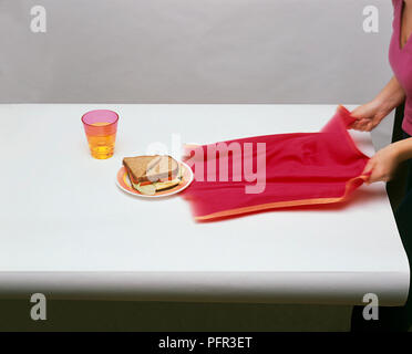 Inching Through Table female hand from under the table grabbing at cookies Stock Photo - Alamy