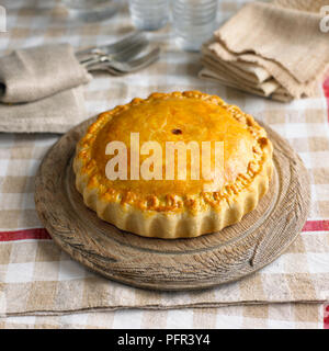 Pork and apple picnic pie on wooden plate Stock Photo