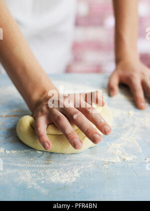 Kneading dough on floured surface, making focaccia bread Stock Photo