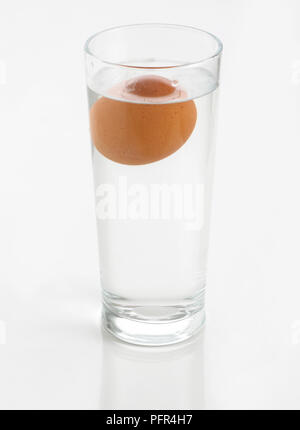 Egg floating in glass of water (sink or float egg freshness test Stock ...