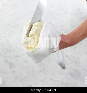 Filling piping bag with butterceam icing using spatula Stock Photo