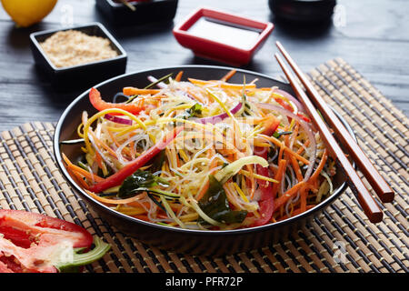 crispy and fresh asian style thin-sliced vegetable salad with wakame seaweed and rice noodle view from above in a bowl, close-up, view from above Stock Photo