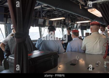 Everett, Wash. (May 21, 2018) Lt. j.g. Ben D. Desotelle, assigned to the Arleigh Burke-class guided-missile destroyer USS Gridley (DDG 101), gives visiting German officers enrolled in the International General/Admiral Staff Officer Course (IGASOC) a tour of the ship's bridge. The tour is part of a visit by IGASOC students to Naval Station Everett. Stock Photo