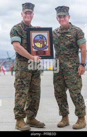 Col. Christopher O’Balle, commanding officer, Marine Light Helicopter Attack Squadron 775(-), Marine Aircraft Group 41, 4th Marine Aircraft Wing, presents a plaque to Sgt. Maj. Craig Carstens, outgoing sergeant major, HMLA-775, MAG-41, 4th MAW, during the relief and appointment ceremony on Marine Corps Air Station Camp Pendleton, Calif., May 24, 2018. Carstens served with HLMA-775 from Oct. 2016 to May 2018 as the squadron sergeant major. Stock Photo