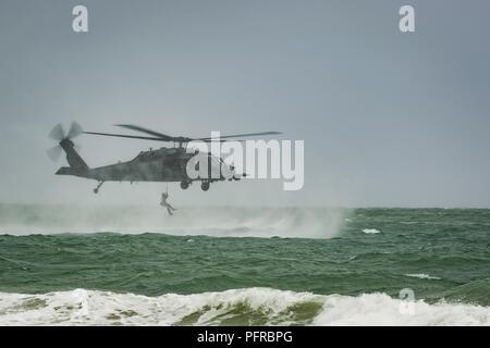 A U.S. Air Force Reserve pararescueman assigned to the 920th Rescue Wing is hoisted aboard an HH-60G Pave Hawk helicopter on May 26th, 2018, during the 2nd Annual Salute to American Heroes Air and Sea Show, in Miami Beach, Florida. This two-day event showcases military fighter jets and other aircraft and equipment from all branches of the United States military in observance of Memorial Day, honoring servicemembers who have made the ultimate sacrifice. Stock Photo