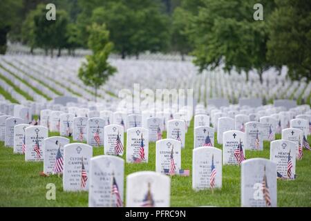 Flags, flowers and other mementos adorn headstones in Section 60 of Arlington National Cemetery, Arlington, Virginia, May 27, 2018. Every year over Memorial Day weekend, more than 135,000 visitors come to Arlington National Cemetery to honor those who have died while in the armed forces. Stock Photo