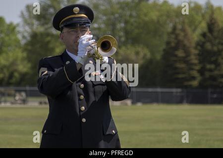 U.S. Army Sgt. 1st Class Chad Jenkins, band musician, 40th Army Band, Garrison Support Command, 86th Troop Command, Vermont National Guard, plays a trumpet during a Memorial Day ceremony at Camp Johnson, Colchester, Vt., May 24, 2018. This ceremony gave Soldiers, Airmen, and family members an opportunity to honor those who have paid the ultimate sacrifice in service to their country. Stock Photo