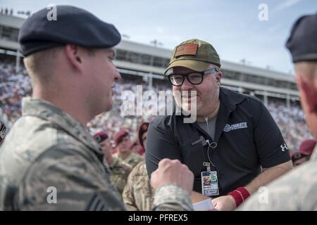 Jon Wilson, pre-race announcer at Charlotte Motor Speedway, speaks to Staff Sgt. Travis Hillard, 4th Security Forces Squadron, during the pre-race events of the Coca-Cola 600 on May 27, 2018, in Concord, North Carolina. More than 600 service members from all five military branches were honored before the NASCAR race. Stock Photo