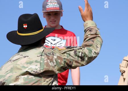 COLLEGE STATION, Texas—A Greywolf Trooper with 2nd Battalion, 82nd Field Artillery Regiment talks to a young visitor about the Paladin self-propelled artillery gun during the inaugural Texas Weekend of Remembrance here, May 26. The weekend-long event was held in order to honor those military members who paid the ultimate sacrifice. Stock Photo