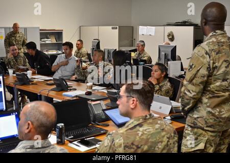 Hilo, Hawaii -- (Left to right) District 1 State Senator Kaiali‘i Kahele, United States Senator from Hawaii Brian Schatz, and Joint Task Force 5-0 Commanding General, Brig. Gen. Kenneth S. Hara, sit down with the JTF 5-0 staff for a situational update May 29, 2018, detailing the on-going National Guard response operations to the 24 lava fissures that have broken out since May 3. Since May 3 more than 200 National Guard Soldiers and Airman have been activated to support on-going support efforts in and around the Puna district on the “Big Island” of Hawaii. Stock Photo