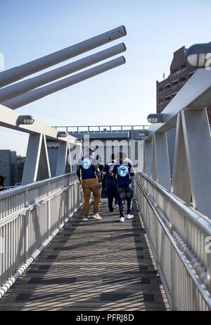 NORFOLK, Va. (May 24, 2018) Sailors from the aircraft carrier USS George H.W. Bush (CVN 77) walk aboard the decommissioned battleship USS Wisconsin (BB 64) as part of a volunteer opportunity through the CPO 365 program. Bush is in port in Norfolk, Virginia, conducting routine training exercises to maintain carrier readiness. Stock Photo
