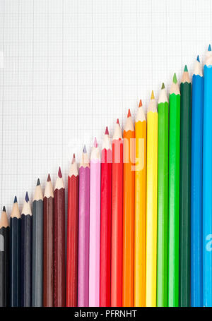 Coloured pencils arranged on graph paper Stock Photo