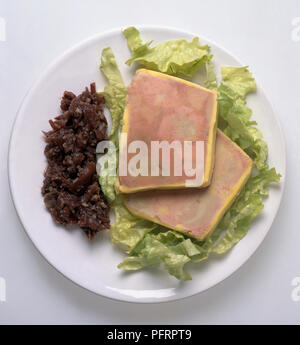 Foie gras terrine with truffles and lettuce served on white plate Stock Photo