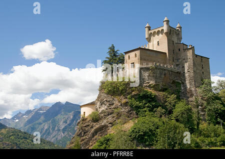 Italy, Valle d'Aosta, Saint-Pierre Castle on outcrop in mountains Stock Photo