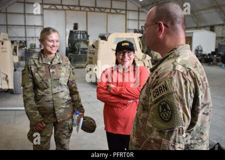 Area Support Group- Kuwait Safety team members; Eva Roberts and Staff Sgt. Emily Nyquist, of the Minnesota Army National Guard; discuss the progress of the solar crosswalk placement on Camp Arifjan, May 30, 2018.  Sgt. First Class John Best, of the 505th Engineer Company, mobilized with the North Carolina National Guard, leaned on his civilian expertise as a civil engineer technician to find solutions for ASG-Kuwait’s solar crosswalk project. He navigated through assembly and installation challenges and coordinated for safe and proper placement of the sets. The solar crosswalk installation is  Stock Photo