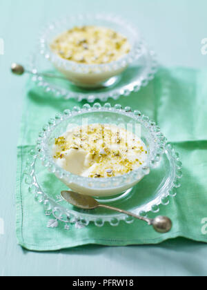 Muhallabia, Middle Eastern milk pudding sprinkled with pistachio nuts Stock Photo