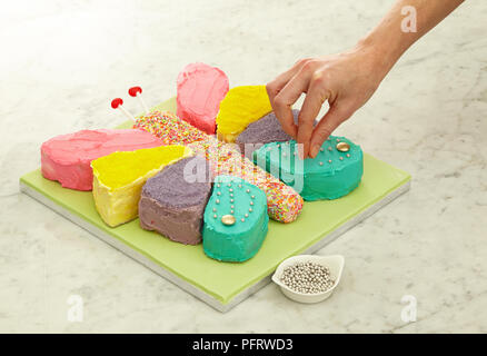 Decorating butterfly cake with edible beads Stock Photo