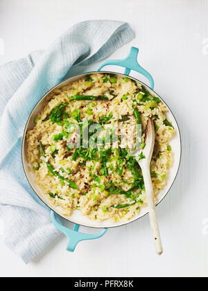 Vegetable risotto in a large pan with wooden spoon Stock Photo