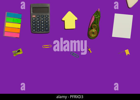 multiple school and office suplies and gadgets lying diagonally on a purple surface. free space for text Stock Photo