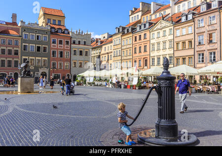 Warsaw - Little boy is playing with pump at historic well in old town market square Stock Photo