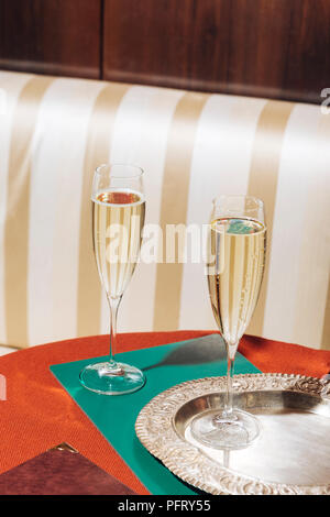 Two flutes of prosecco in an elegant bar with vintage pop colors Stock Photo