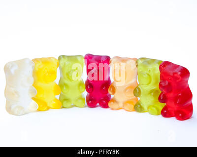 Gummy bears candy in a row on white isolated background. Stock Photo