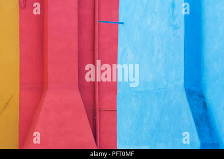 Close up view of exterior wall of a colorful painted houses on Burano island, Venice, Italy. That island is famous for beautiful mixed colored houses. Stock Photo