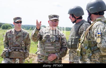 Yavoriv, Ukraine – Maj. Gen. Raymond Shields, commander of the New York Army National Guard meets with U.S. and Ukrainian Soldiers during a visit to the Yavoriv Combat Training Center here May 25. During his visit Shields met with JMTG-U leaders and awarded challenge coins to U.S. service members to recognize them for their hard work. Stock Photo