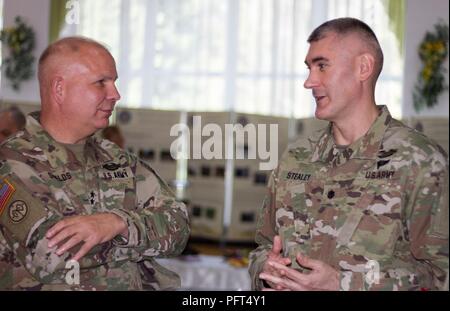 Yavoriv, Ukraine – Maj. Gen. Raymond Shields, commander of the New York Army National Guard meets with Lt. Col. Robert Stealey, the Joint Multinational Training Group – Ukraine chief of staff, during a visit to the Yavoriv Combat Training Center here May 25. During his visit Shields met with JMTG-U leaders and awarded challenge coins to U.S. service members to recognize them for their hard work. Stock Photo